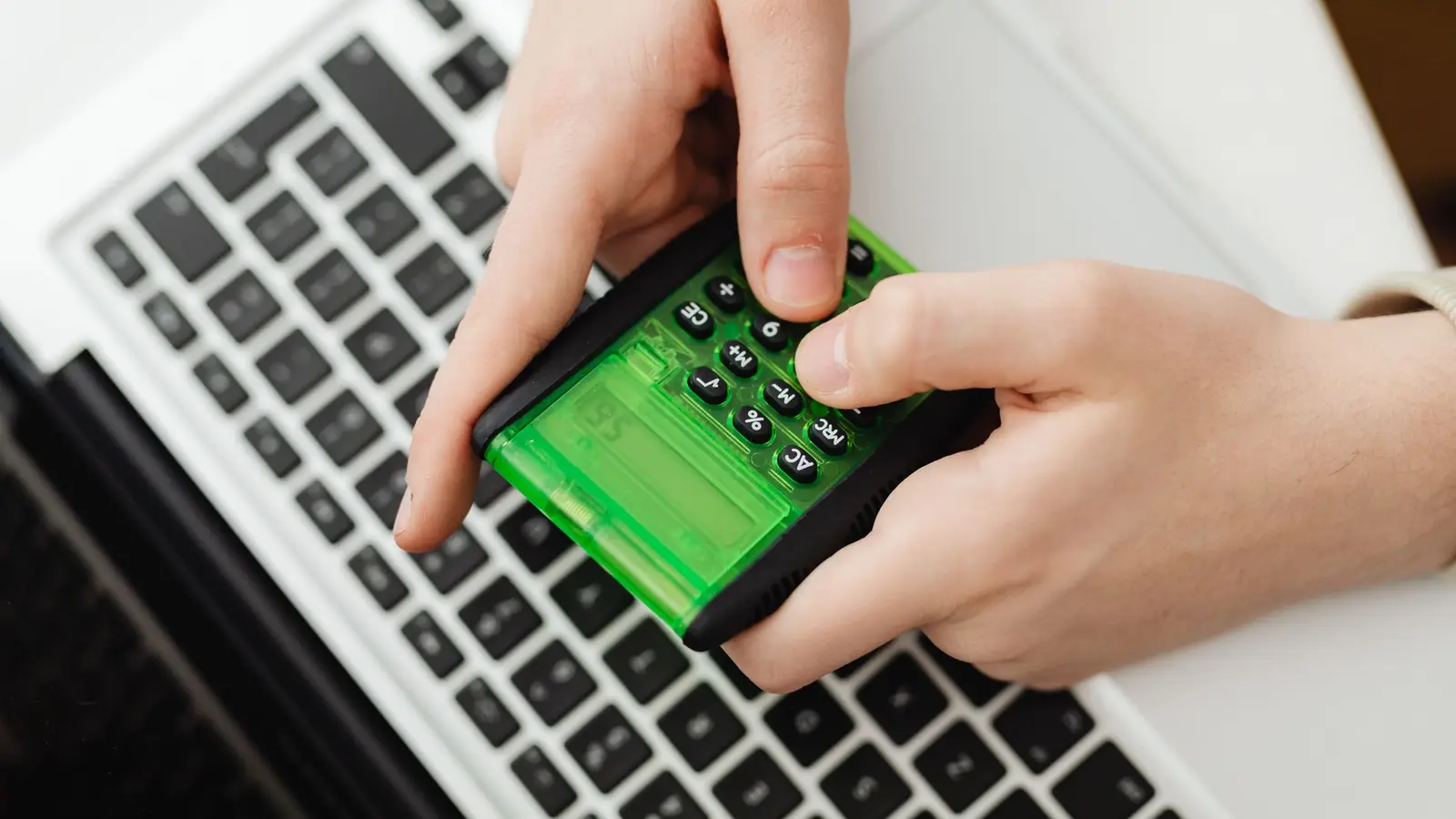 De kosten en commissie van een bijlesplatform uitrekenen met een rekenmachine naast een laptop